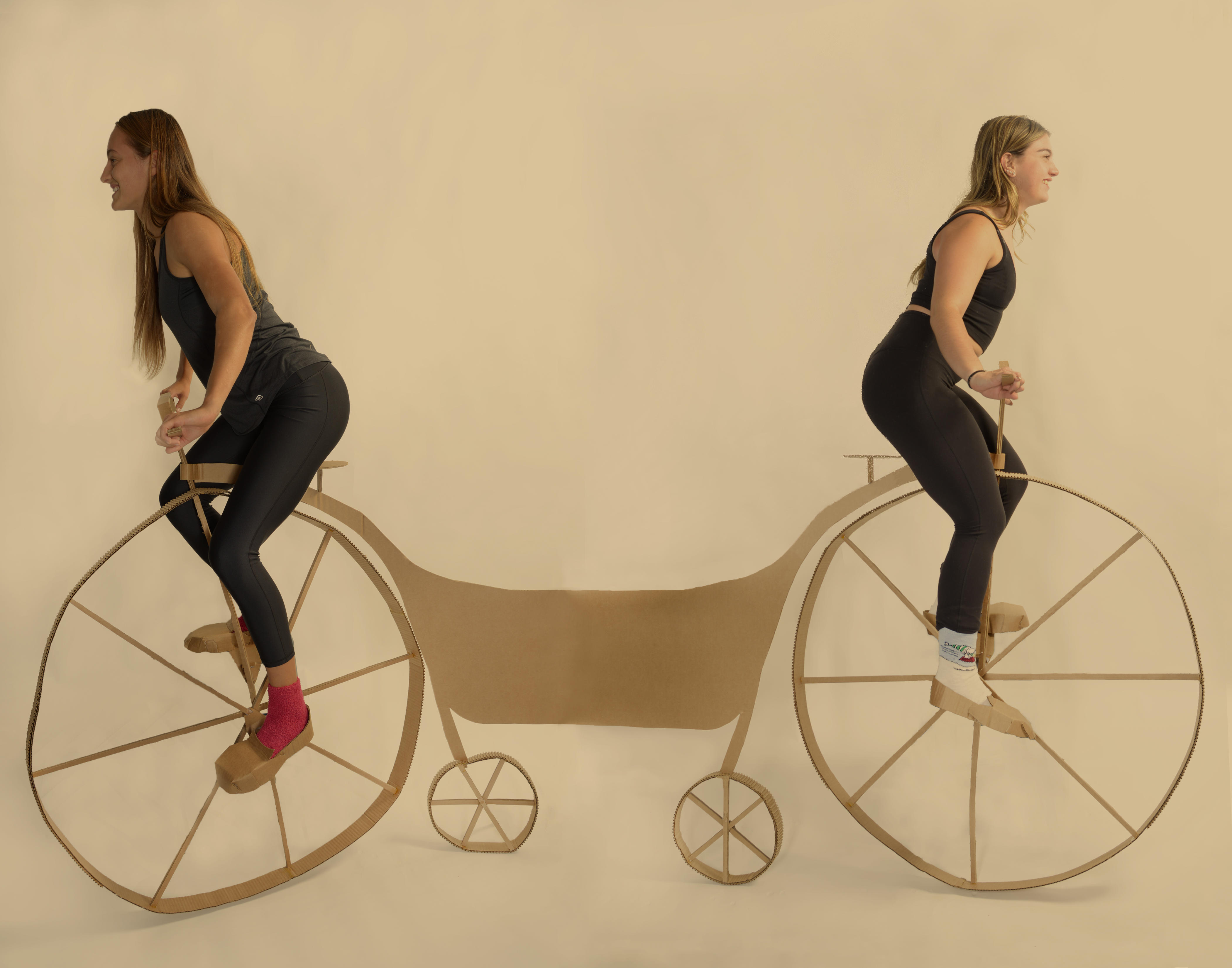 two women on a cardboard bike