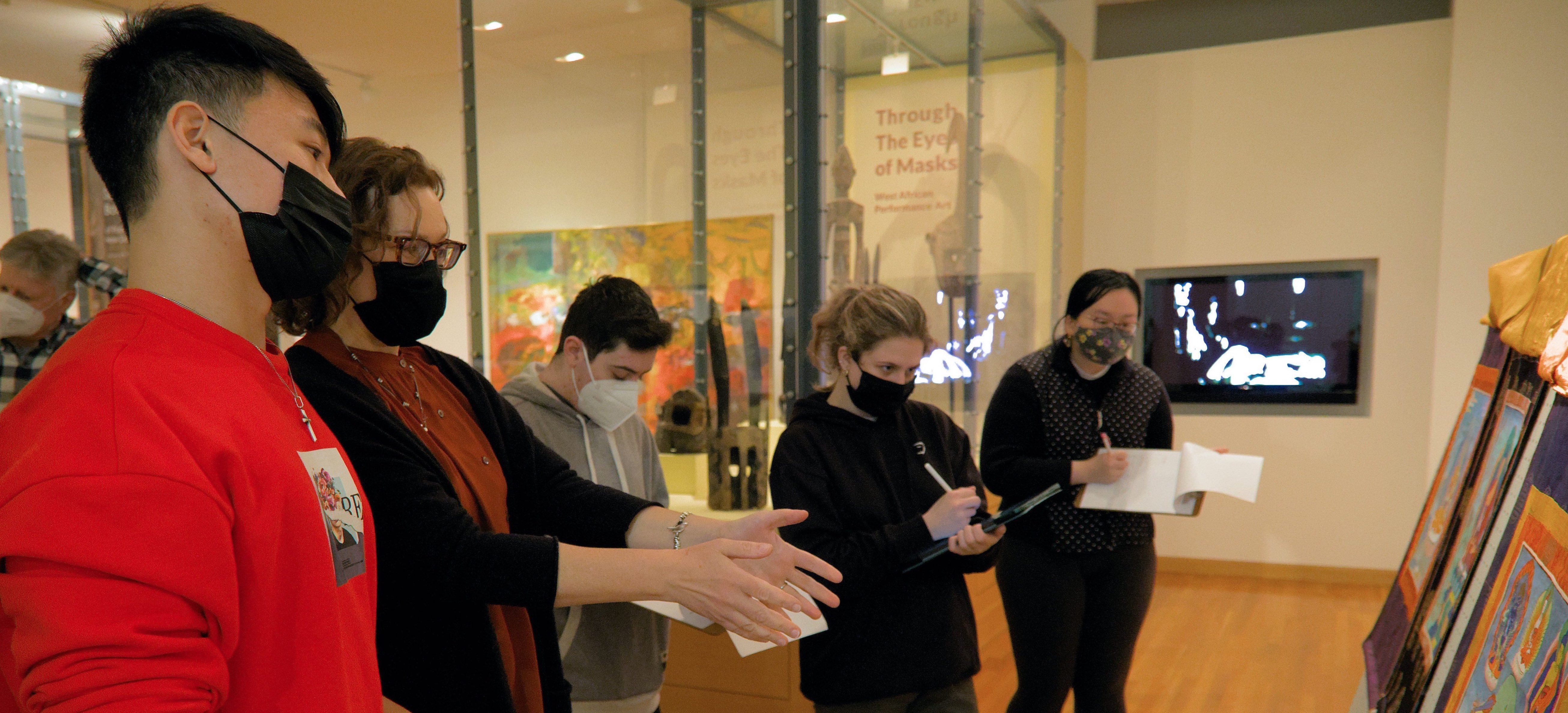 Students in Dr. Annabella Pitkin's class examine Buddhist artworks in the Lower Gallery